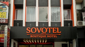 A building with a sign reading "SOVOTEL Boutique Hotel" at the top and bottom.