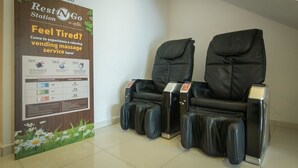 A massage chair area with a poster advertising a relaxing massage service.