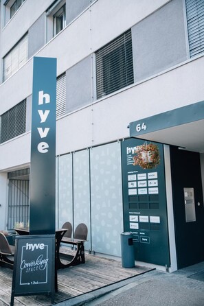 A modern building with a sign reading "hyve coworking space" and a door marked "64". - Hyve Hotel Basel - Hostel (Basel)
