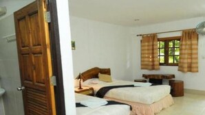 A room with two beds, a wooden door, a window with curtains, and a small table. - Ruan Mai Sang Ngam Resort (Sa Khu)