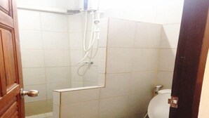 A small, compact bathroom with a toilet, a shower, and a sink. - Ruan Mai Sang Ngam Resort (Sa Khu)