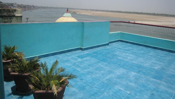 A rooftop pool with blue tiles and potted plants. - Kedareswar Bed and Breakfast (Varanasi)