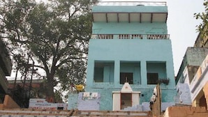 A light blue building with a flat roof and a small entrance. - Kedareswar Bed and Breakfast (Varanasi)