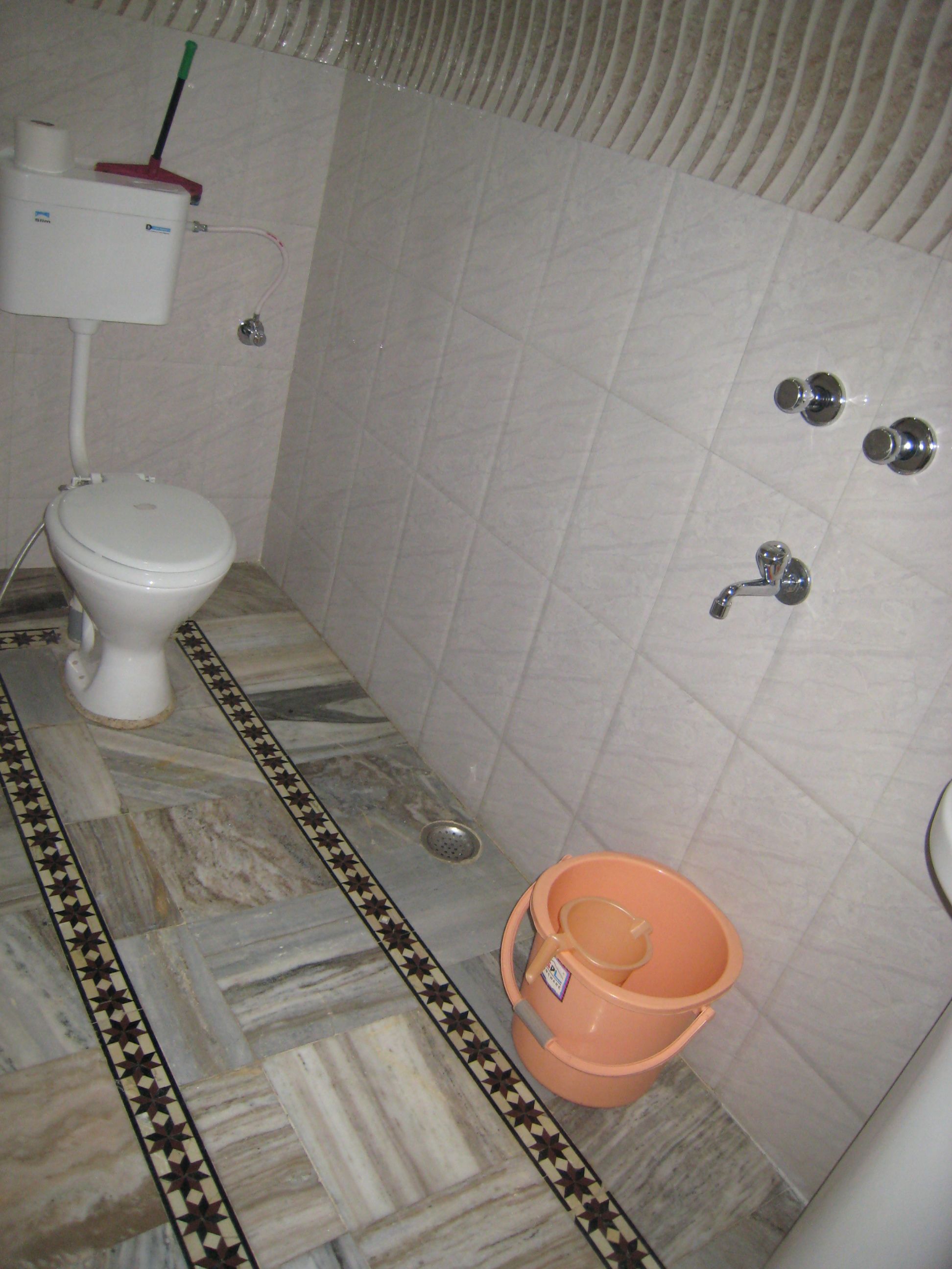 A bathroom with a toilet, a shower, and a bidet.