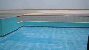 A pool area with a view of a beach and a distant shoreline. - Kedareswar Bed and Breakfast (Varanasi)