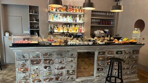 A bar area with a variety of beverages, snacks, and a vintage-style storage unit. - Residenza dell'Opera (Turin)
