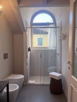 Un baño moderno con cabina de ducha de vidrio, inodoro y lavamanos.