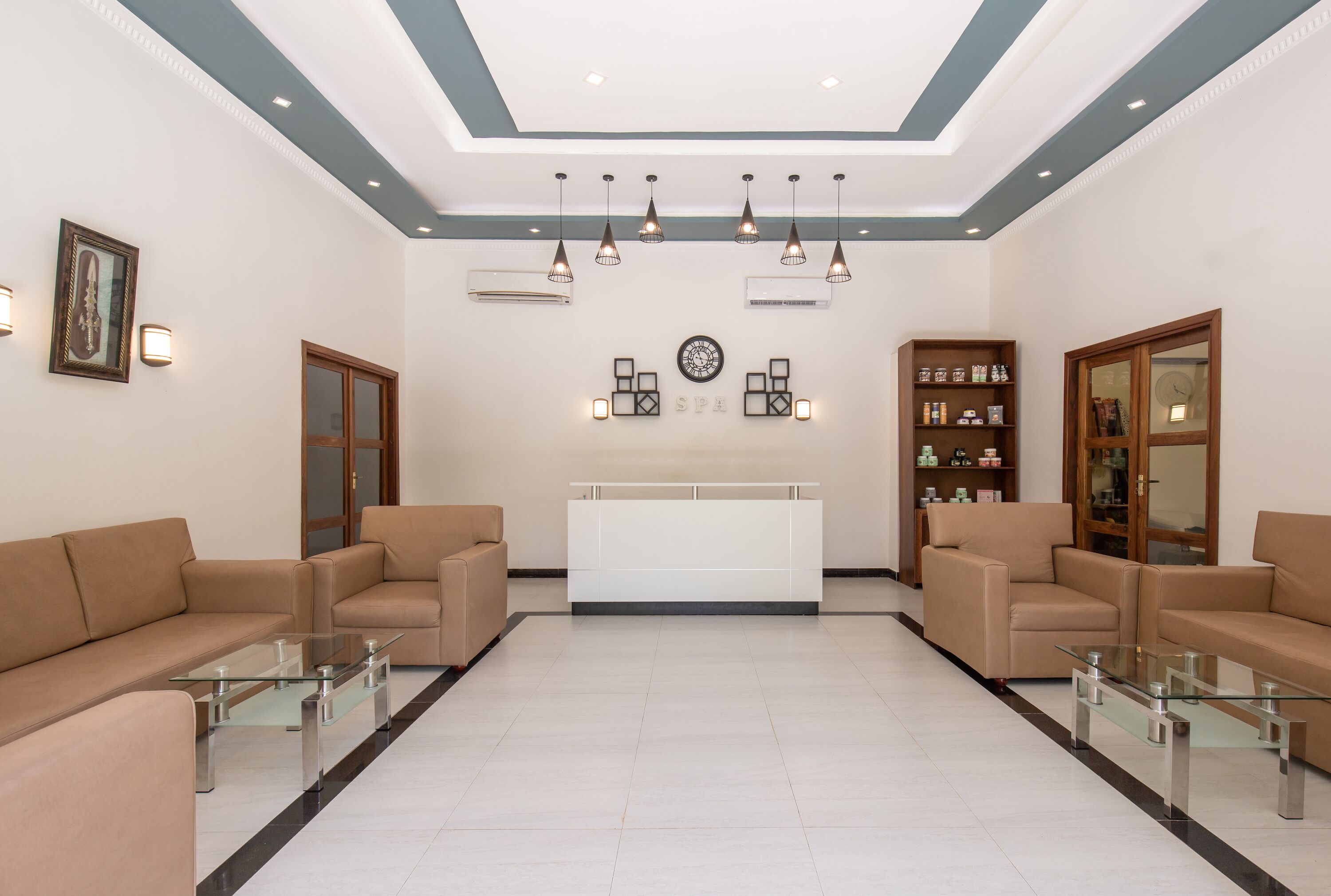 A reception area with a reception desk, two sofas, and a glass coffee table.