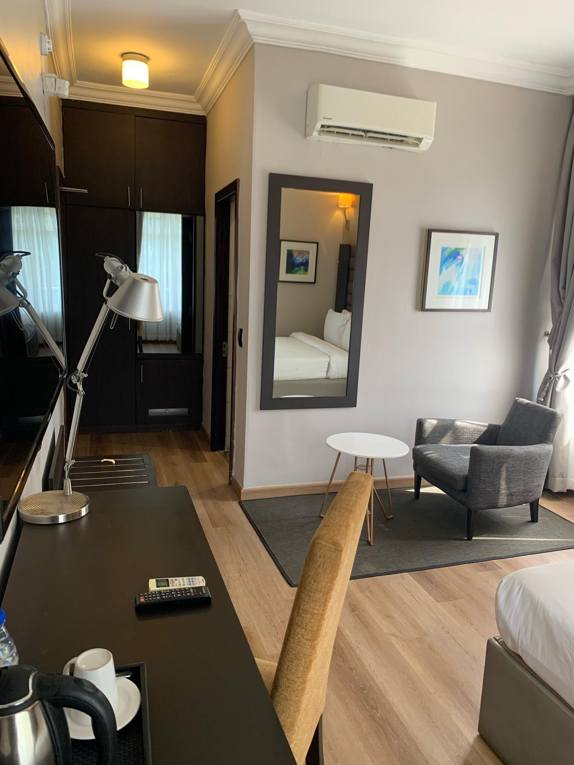 Une chambre d’hôtel équipée d’un bureau, d’une chaise, d’un lit et d’une petite table.