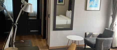 Une chambre d’hôtel équipée d’un bureau, d’une chaise, d’un lit et d’une petite table.