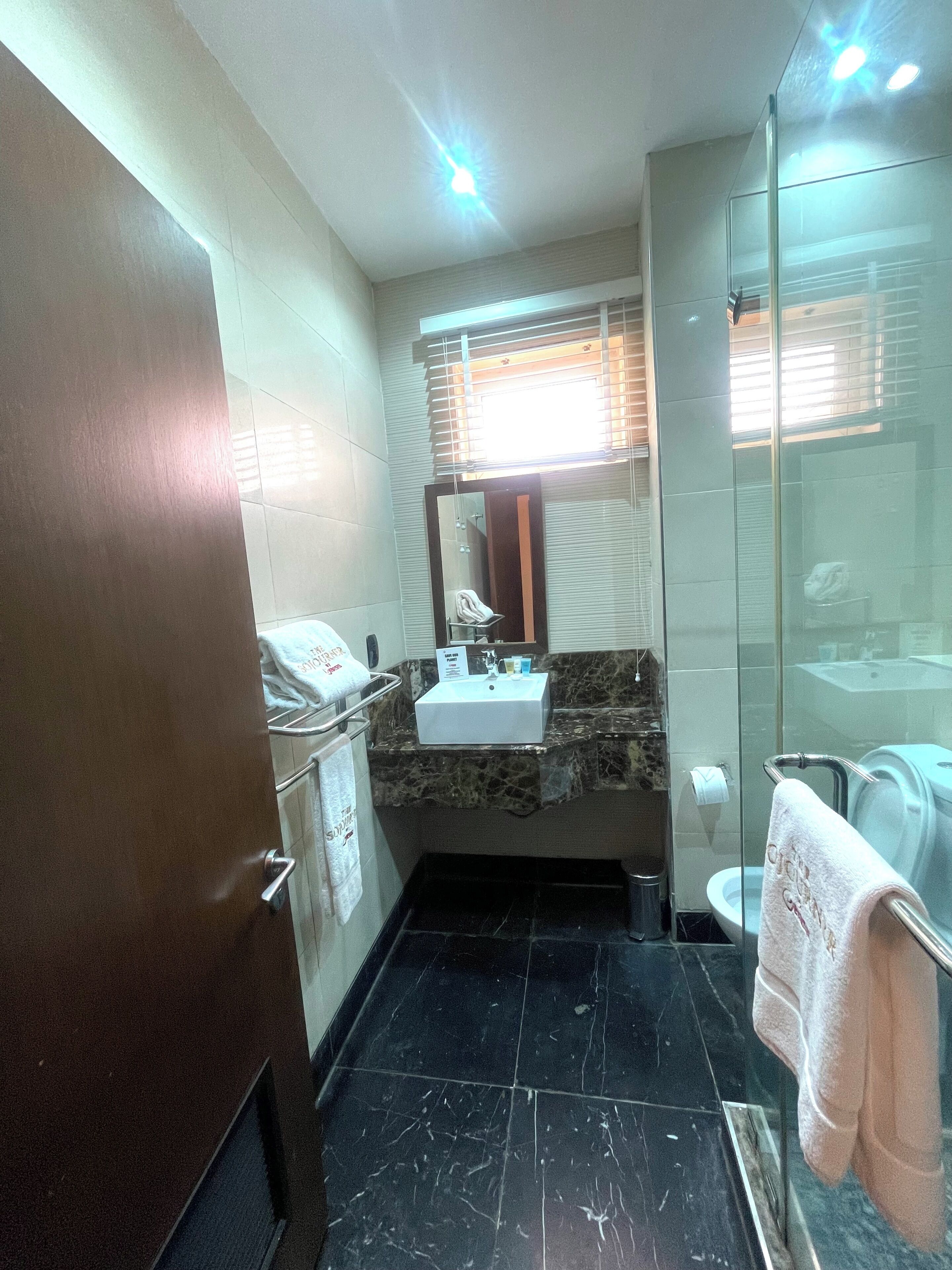 A compact bathroom with a sink, mirror, and toilet.