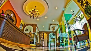 A lobby with a checkered floor, a reception desk, a chandelier, and a staircase. - Coasta Bangsaen (Chonburi)