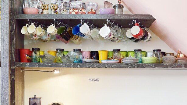 A kitchen with wooden cabinets, a coffee machine, and various kitchen utensils and containers. - Feng's B&B (Hualien City)