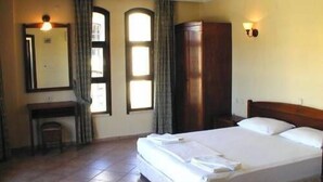 A hotel room with a bed, a desk, a chair, and a wardrobe. - Club Turquoise Apartments (Marmaris)