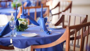 A dining table set with blue tablecloths, white plates, and clear glassware. - Waterside Bentota (Bentota)
