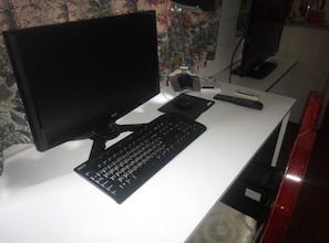 Work in comfort with a dedicated workspace featuring a desk, computer, and television.