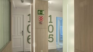 A hallway with doors numbered 106 and 105, a fire alarm, and a security camera. - Hotel Mar del Plata (A Coruña)