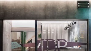 A hotel entrance with a modern design, featuring a reception desk and a staircase leading to the interior. - Hotel Mar del Plata (A Coruña)