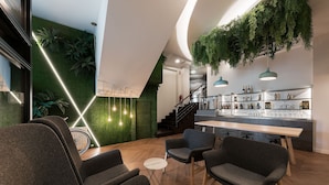 A modern interior with a bar area, seating, and a staircase. - Hotel Mar del Plata (A Coruña)