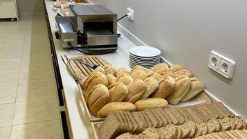 A buffet setup with various breads and pastries.