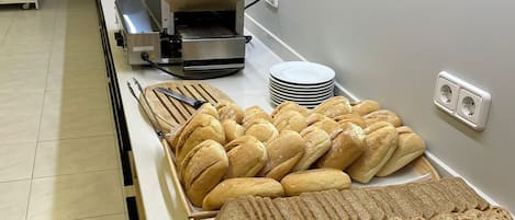 A buffet setup with various breads and pastries.