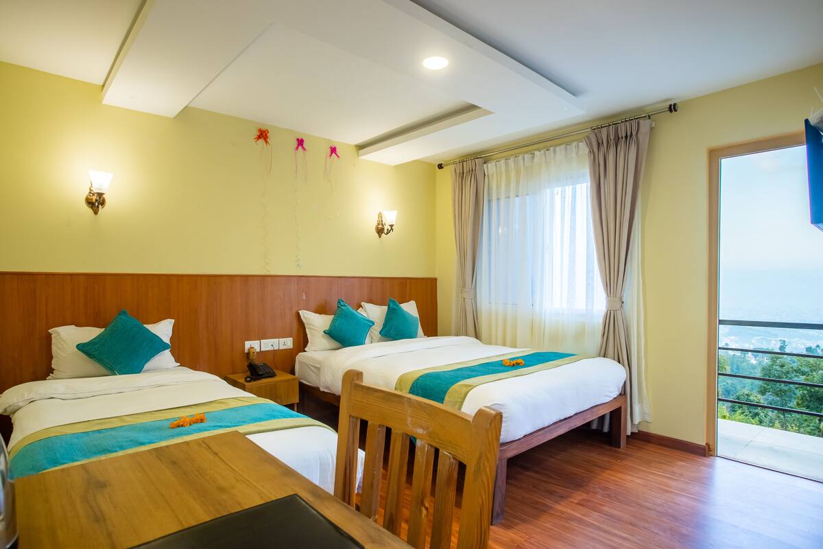 A hotel room with two beds, wooden headboards, and a balcony with a view.