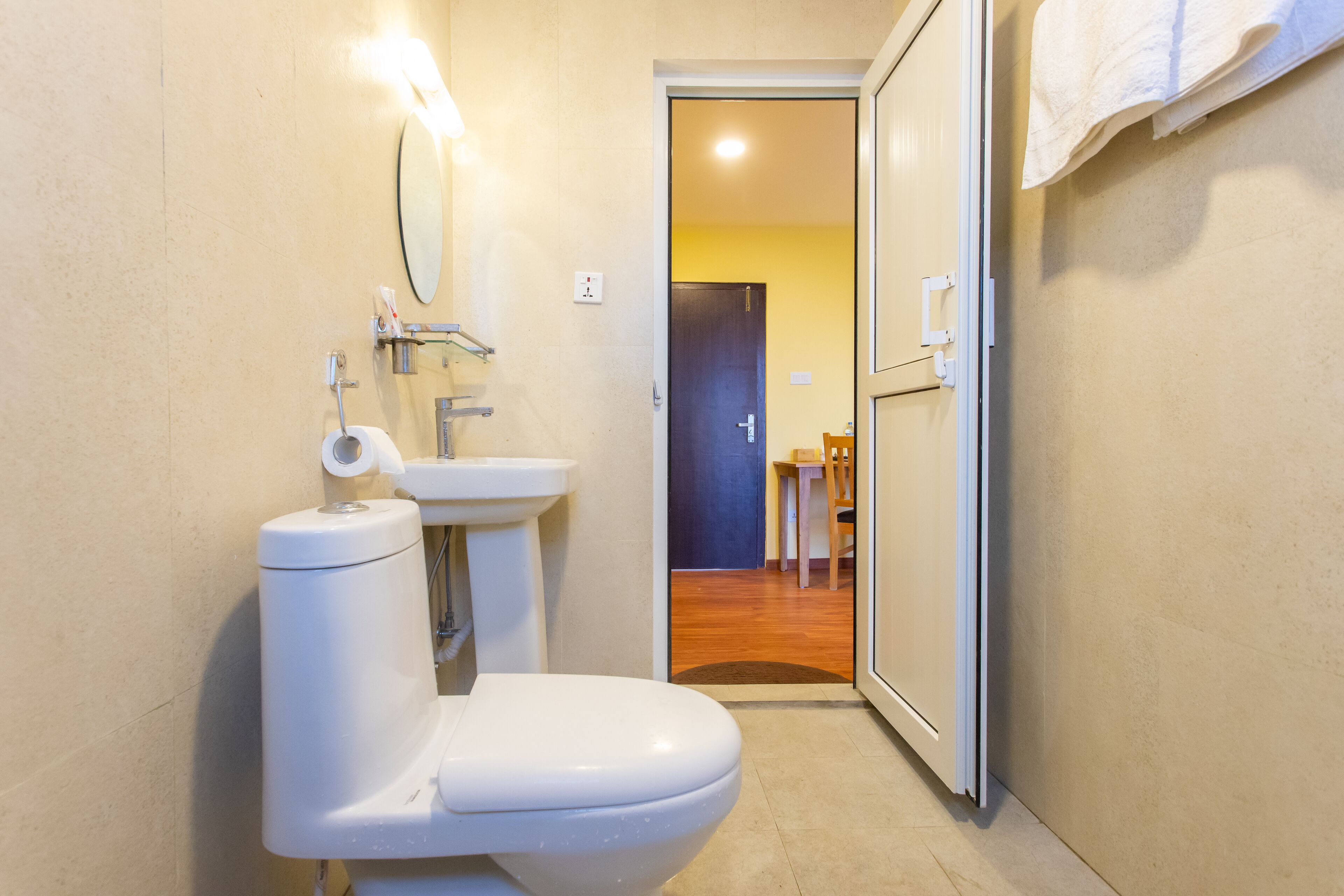 A compact bathroom with a toilet, sink, and mirror.