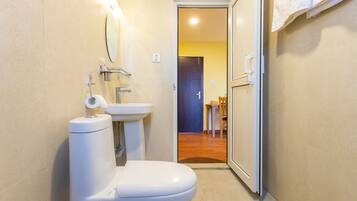 Un baño pequeño con inodoro, lavabo y espejo.