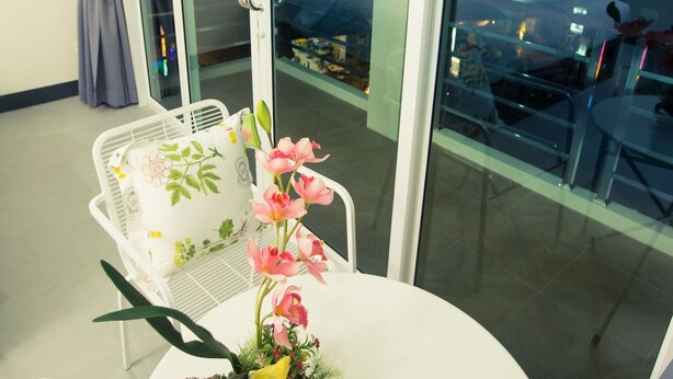 Ein Balkon mit Esstisch, Stuhl und einer dekorativen Pflanzengestaltung.
