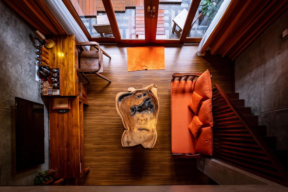 A room with a wooden wall, a wooden bench, and a staircase.