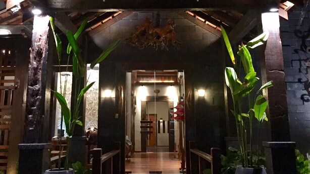 A wooden structure with a roof, flanked by large potted plants, leading to a door. - Ipoh Bali Hotel (Ipoh)