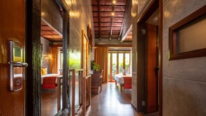 A hallway with wooden flooring, a staircase, and a bed with a red blanket. - Ipoh Bali Hotel (Ipoh)