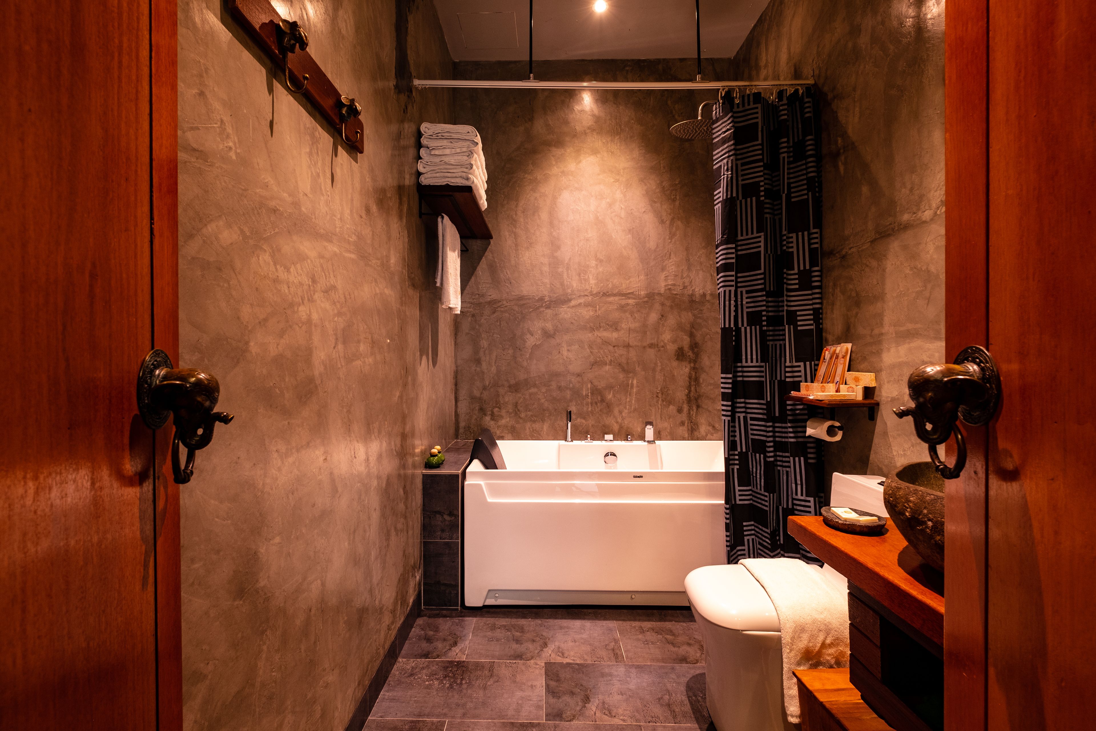 A modern bathroom with a bathtub, toilet, and sink.