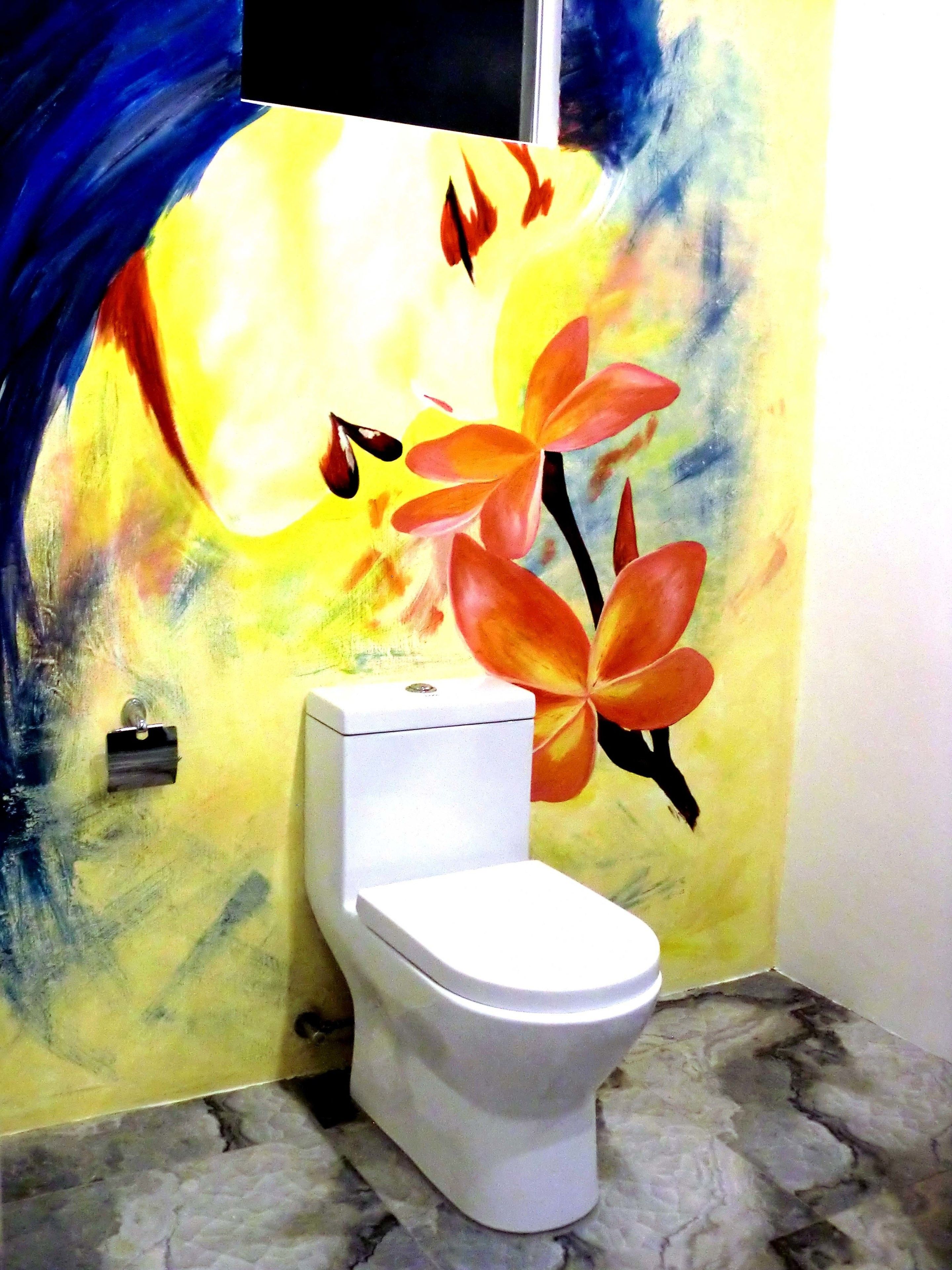 A bathroom with a white toilet, a marble floor, and a colorful abstract painting on the wall.