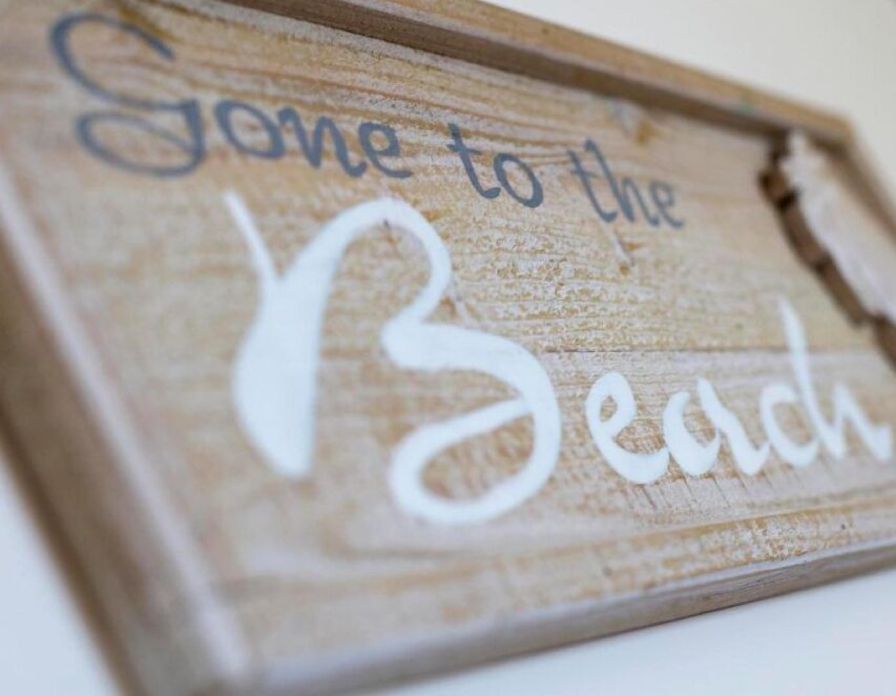 A wooden sign with the text "Gone to the Beach".