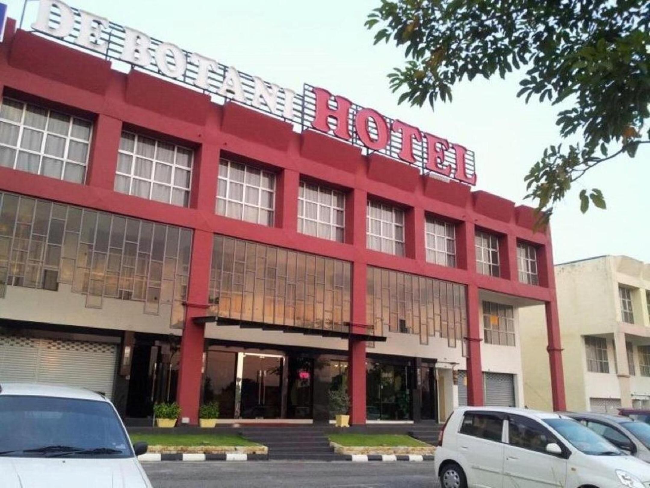 A hotel with a red facade and large windows.