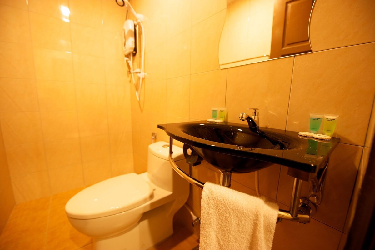 A bathroom with a toilet, a sink, and a towel rack.