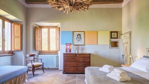A bedroom with a bed, a chair, a dresser, and a window. - Palazzo Gatteschi (Poppi)