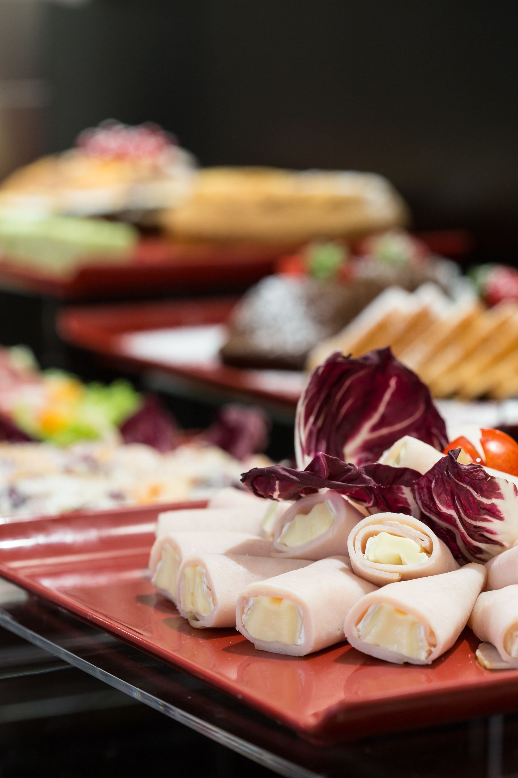 Un buffet con diversi piatti, tra cui panini e verdure.
