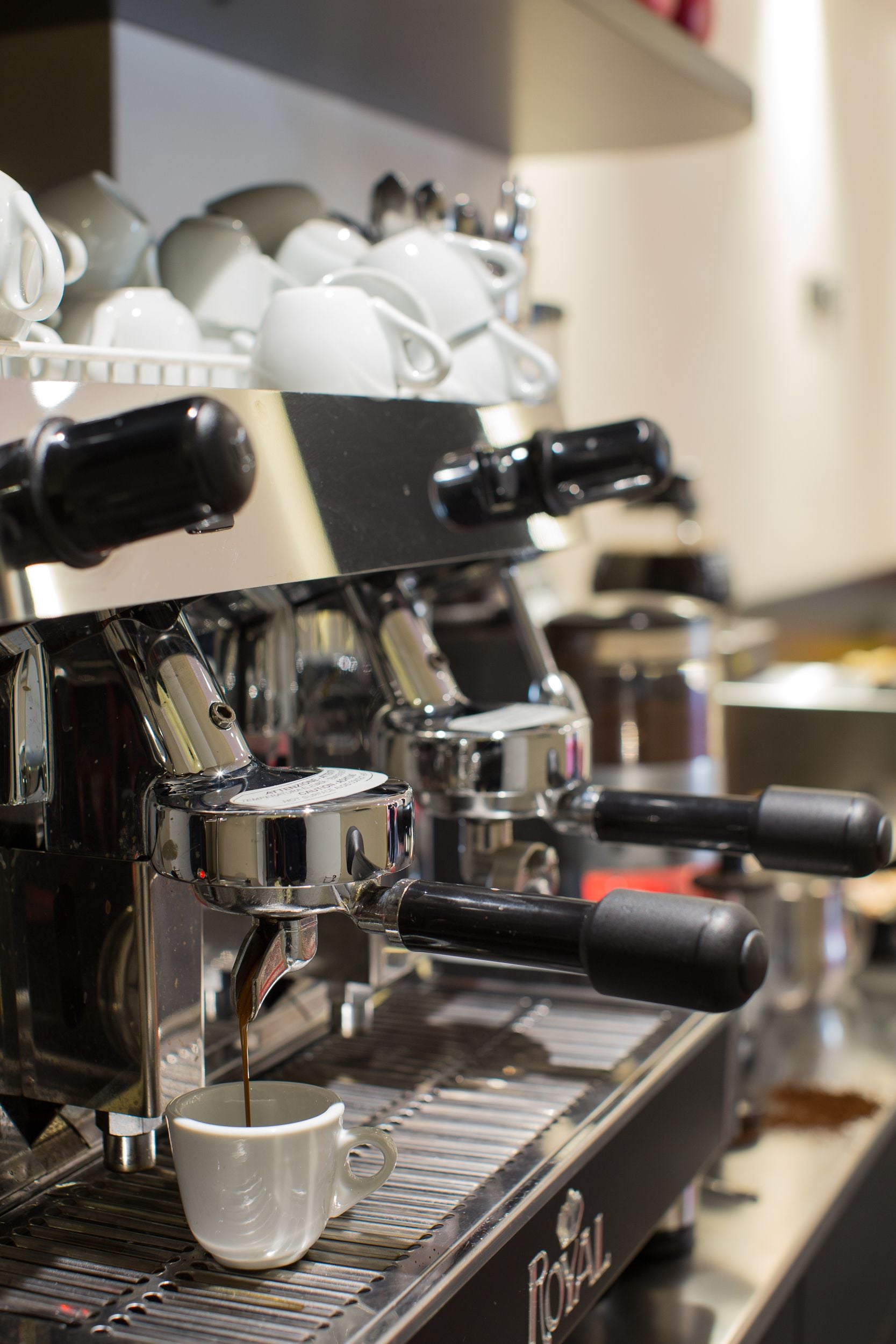 A coffee machine with a cup of coffee being dispensed.