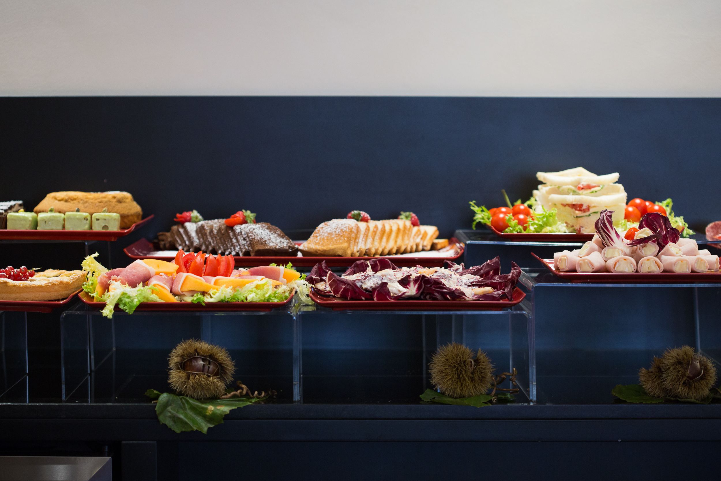 A buffet with various food items including pastries, sandwiches, and salads.