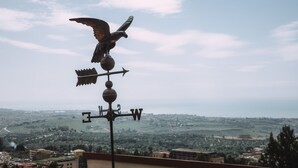 A weather vane with an eagle design, a compass, and a wind direction indicator. - B&B Triskéles (Agrigento)