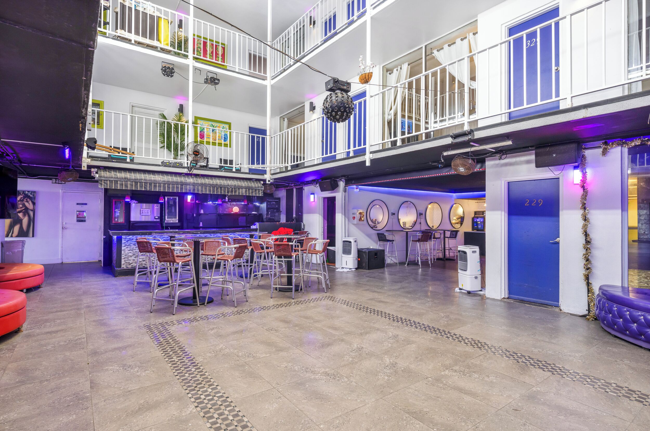 Un espacio interior de varios niveles con una zona de bar, asientos y un suelo a cuadros.