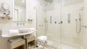 A modern bathroom with a glass-enclosed shower, a sink, and a vanity with storage.