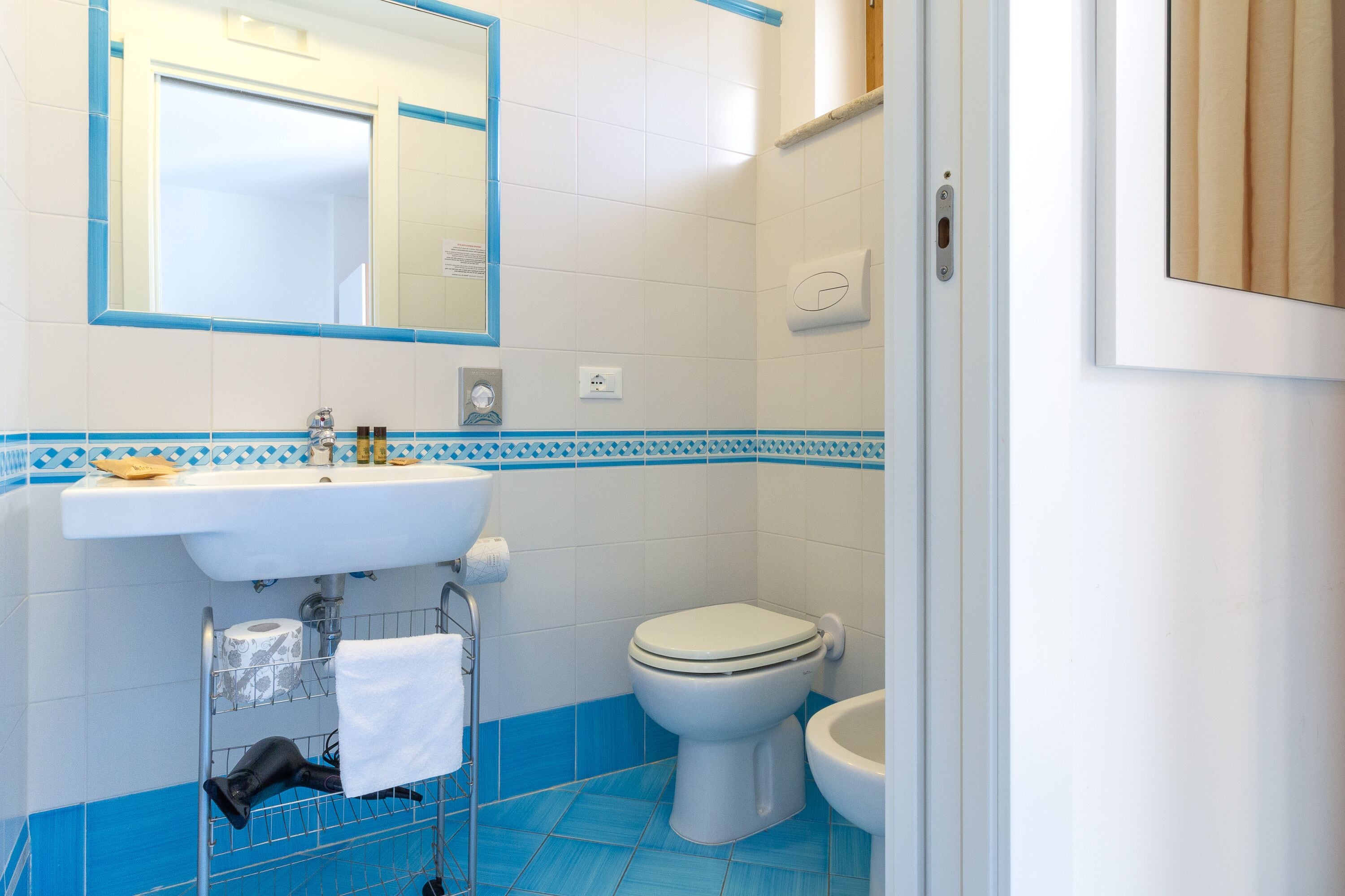 Une salle de bain avec un lavabo, des toilettes et un miroir.