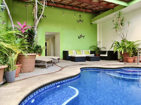 Una piscina al aire libre, sillones reclinables de piscina