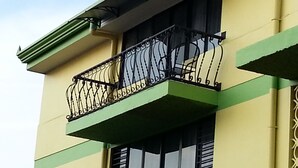 A building with a balcony featuring ornate black metal railings and a green and yellow color scheme. - Hotel La Guaria Inn & Suites (Alajuela)