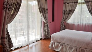 Un dormitorio con cama, cortinas y ventana.