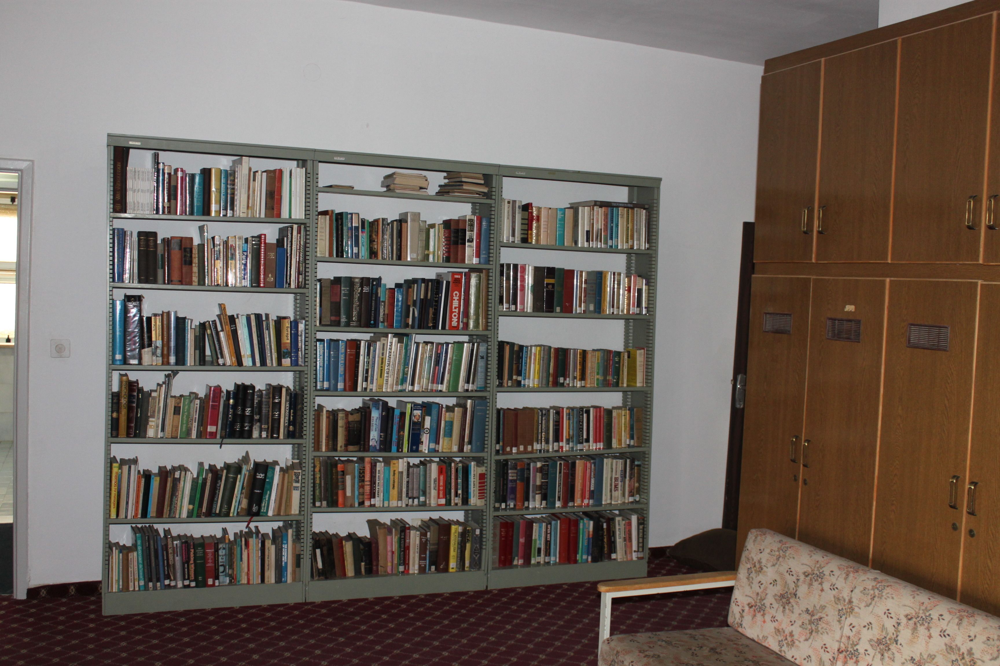 Una biblioteca con estanterías y un aparador de madera.
