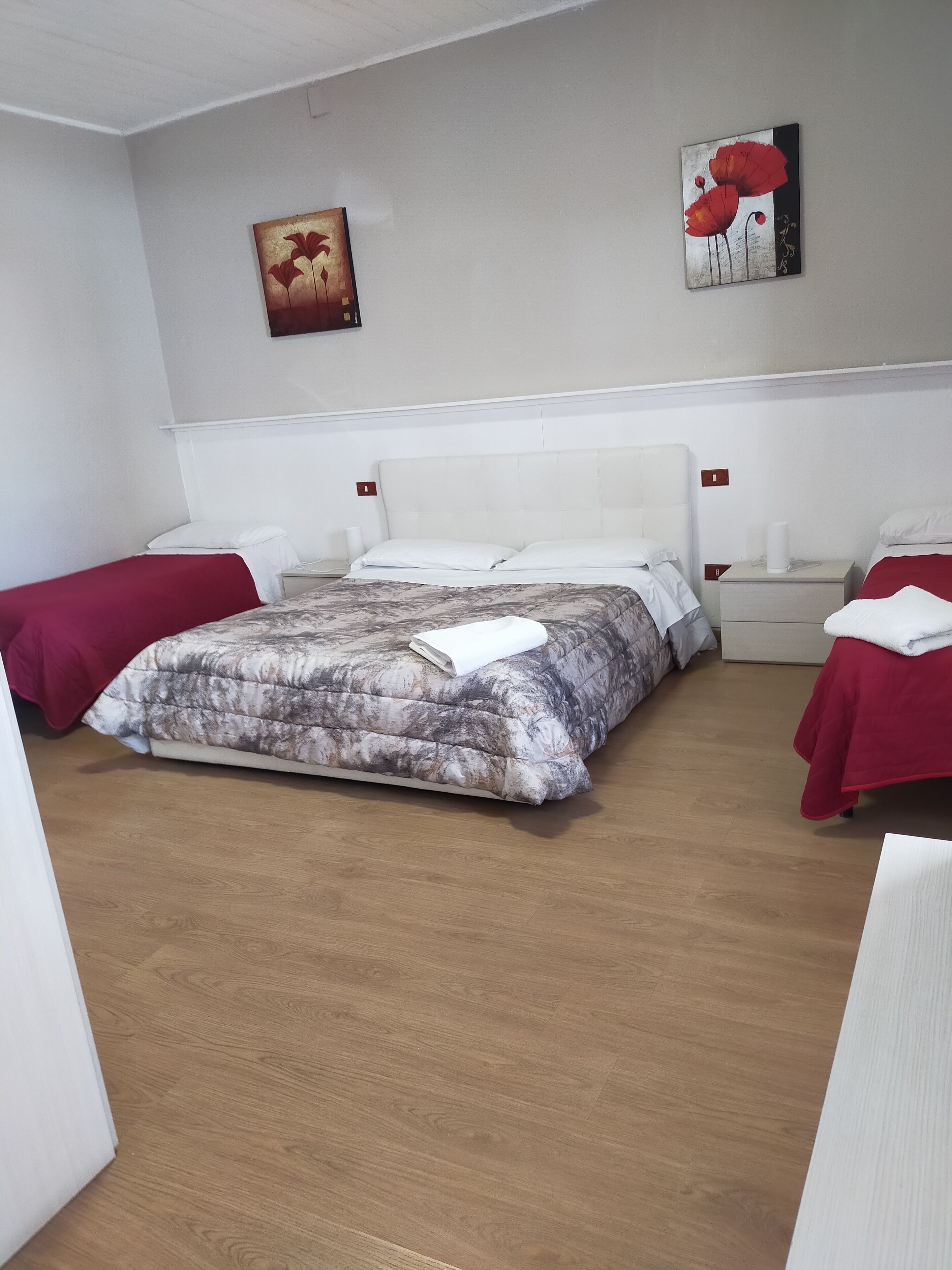 A hotel room with a large bed, two bedside tables, and a painting on the wall.